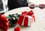 Red flower bouquet and wrapped gift on a table for Valentine's Day celebration