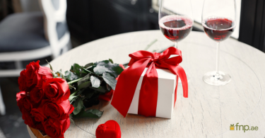 Red flower bouquet and wrapped gift on a table for Valentine's Day celebration