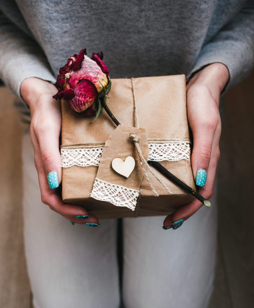 Women holding gift wrapped beautifully with rose
