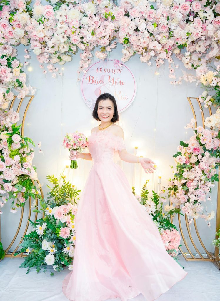 Bride standing in front of Pink Floral Backdrop wall