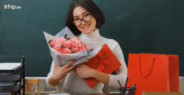 A holding flower bouquet and gift in her hand given by employees