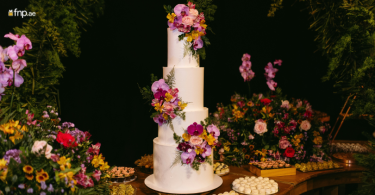 A beautifully decorated 3 tier wedding cake with floral decorations
