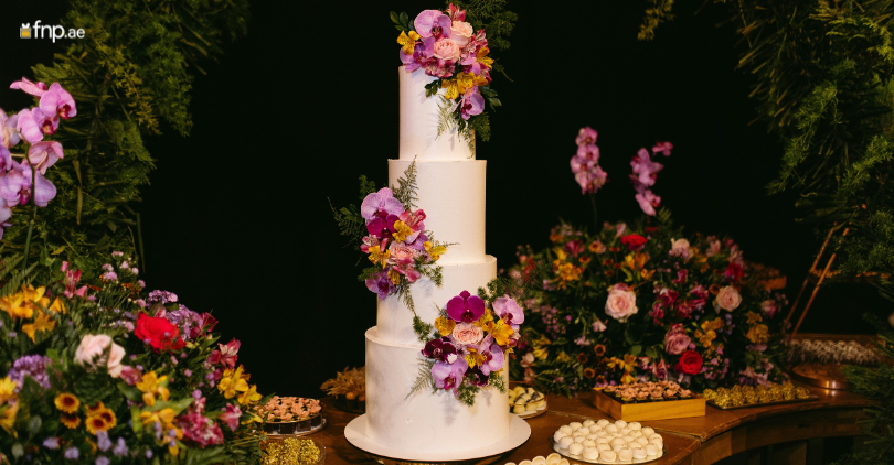 A beautifully decorated 3 tier wedding cake with floral decorations
