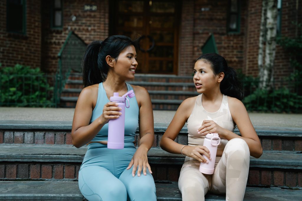 Mother and Daughter Drinking water after doing some sports activities