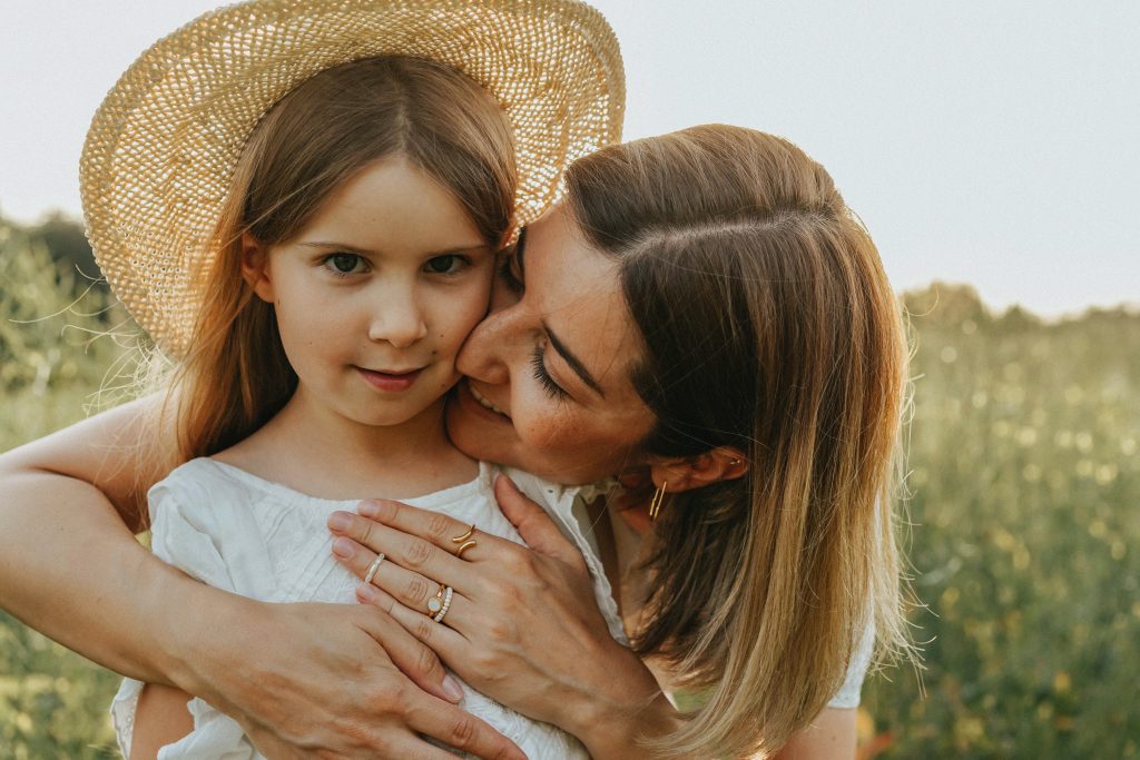 A mother hugging her little daughter with love