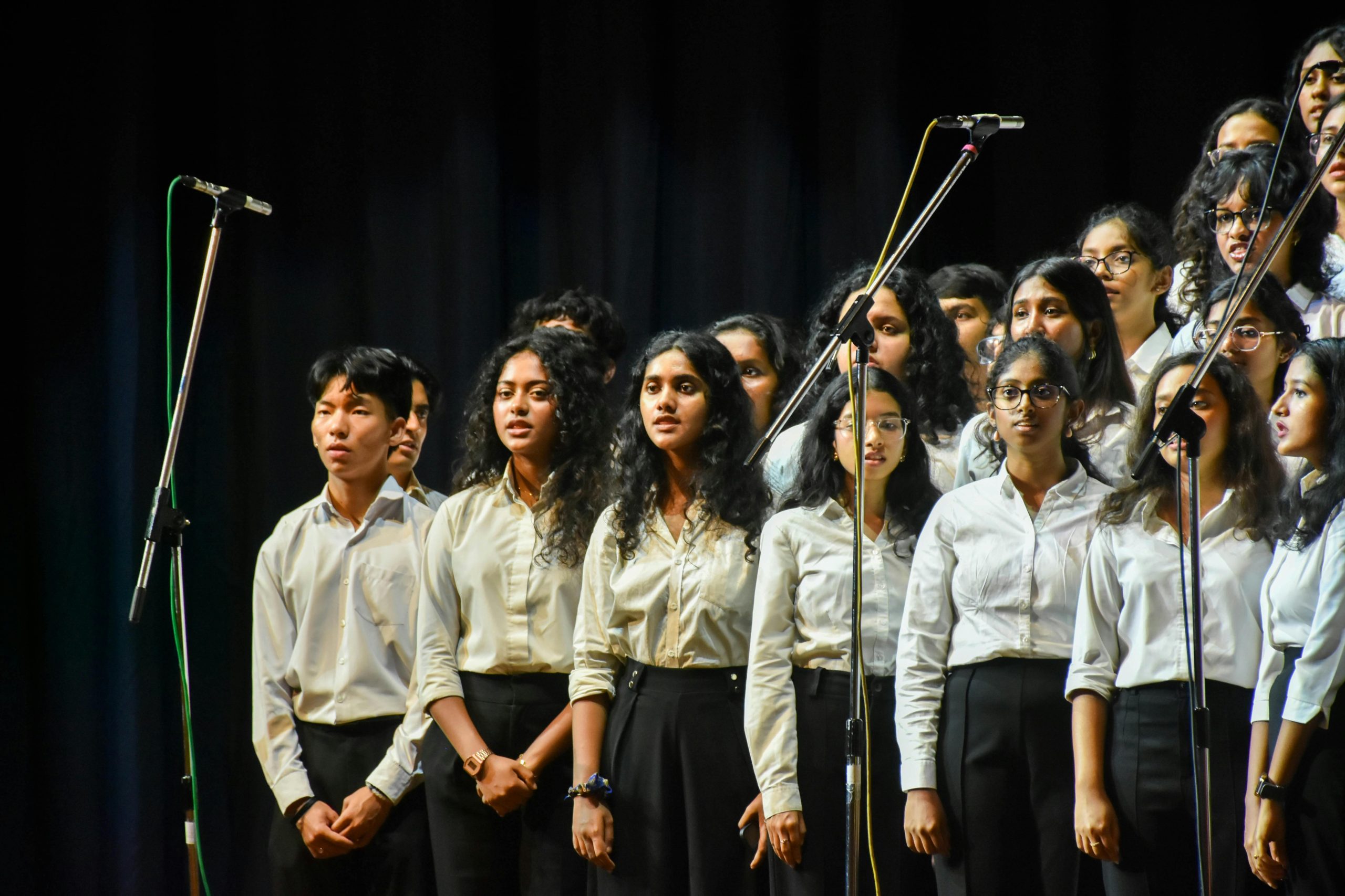 Student singing in group at talent show in school