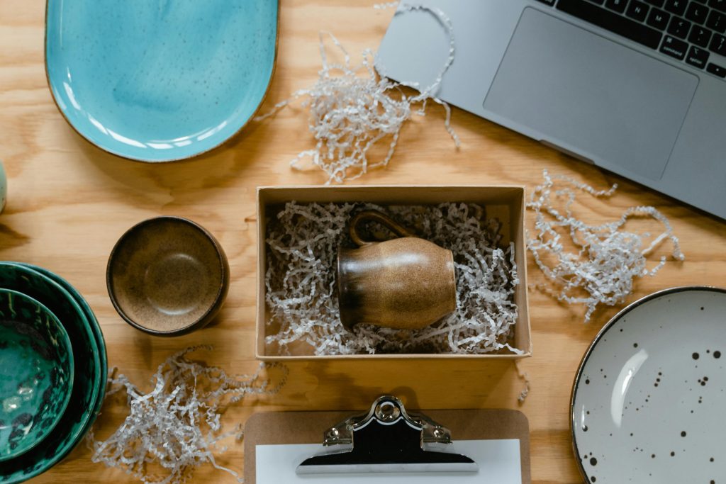 A gift box with wooden cup kept in shredded kraft paper