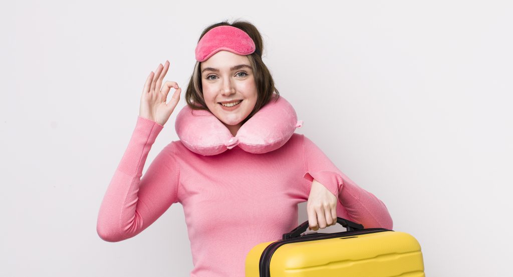A Women with Sleep Masks on her head and Neck Pillows around her neck