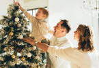 A happy family touching their decorated Christmas Tree with hands