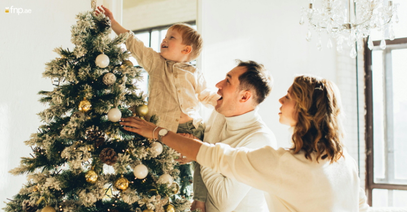 A happy family touching their decorated Christmas Tree with hands