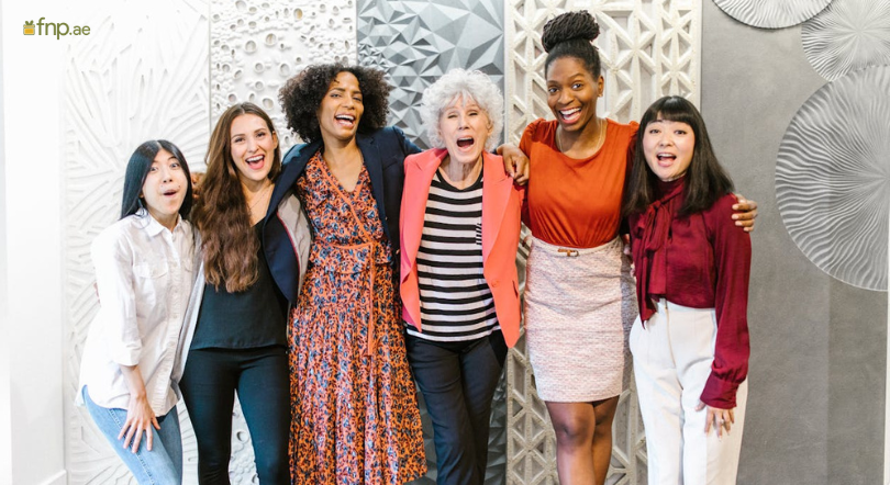 Women from different backgrounds standing Together in office