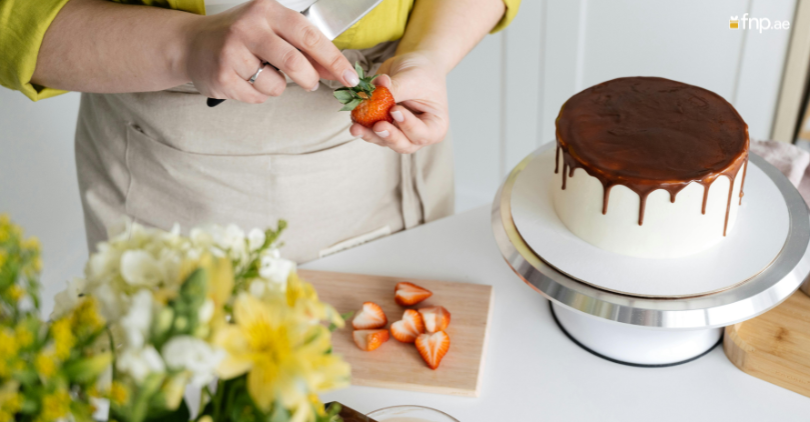 A Woman making strawberry Topping for her delicious Cake