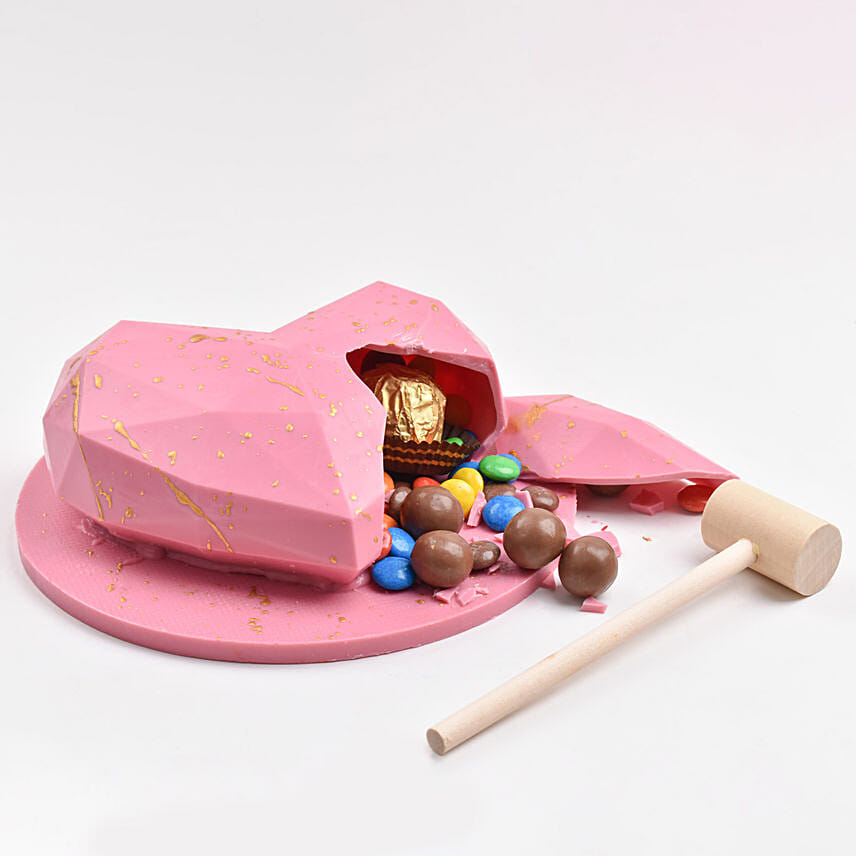 Pink heart shape pinata chocolate with hammer to smash it